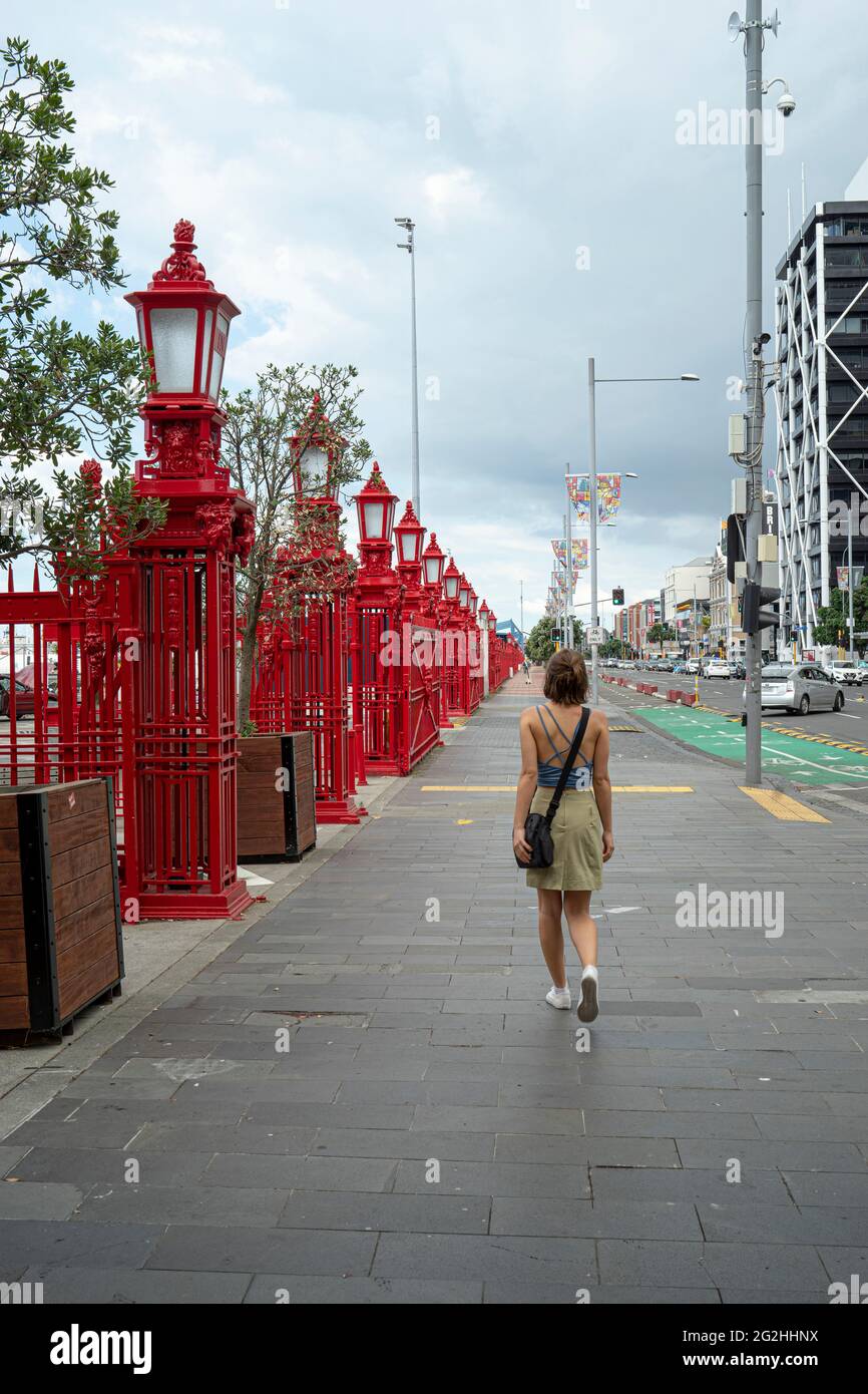 Woman at the Red Fence at Queens Wharf, part of Auckland Harbor, Auckland Province, North Island, New Zealand Stock Photo