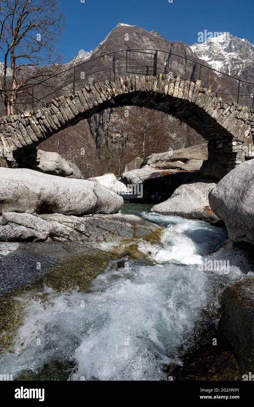 In a tiny side valley of the Valle Maggia, this ancient stone bridge spans a small mountain stream. Stock Photo