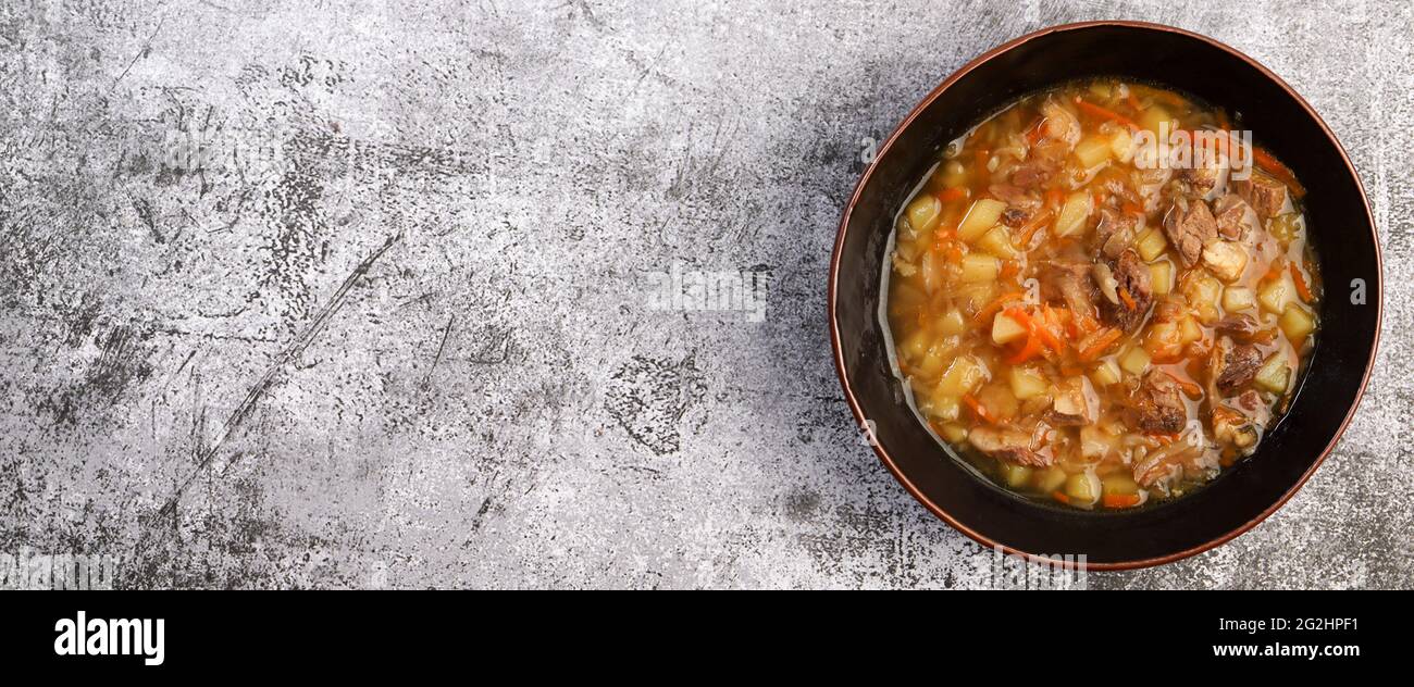 Shchi - traditional russian soup with beef and sauerkraut in a bowl on a dark background. Top view, flat lay Stock Photo