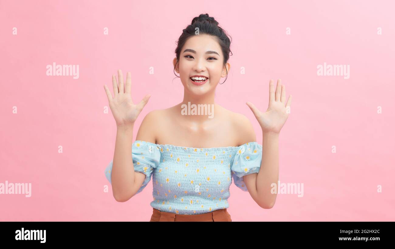 Smiling beautiful young woman posing with hands on face Stock Photo - Alamy