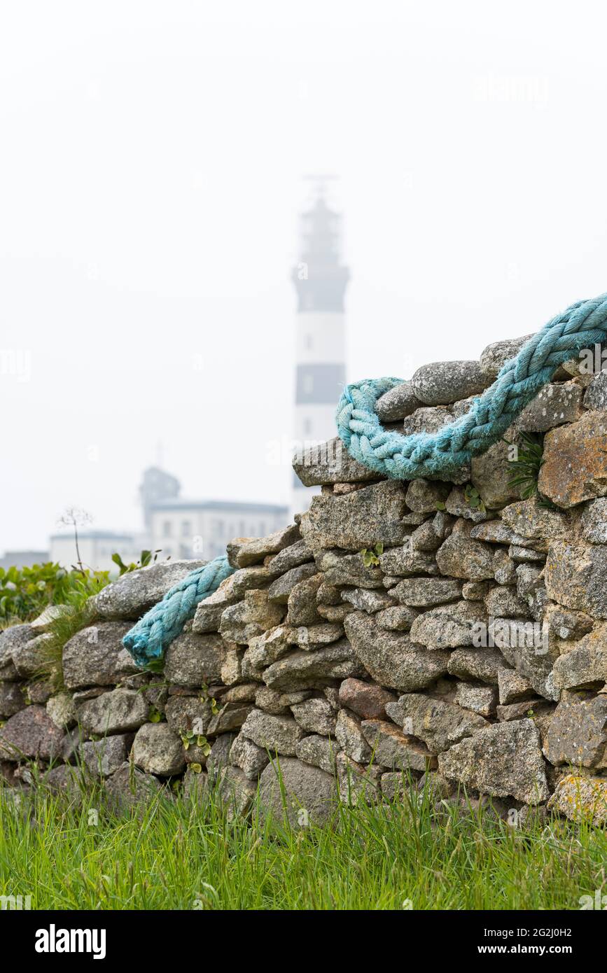 Stone wall and lighthouse Créac'h, foggy mood, Île d´Ouessant, France, Brittany, Finistère department Stock Photo