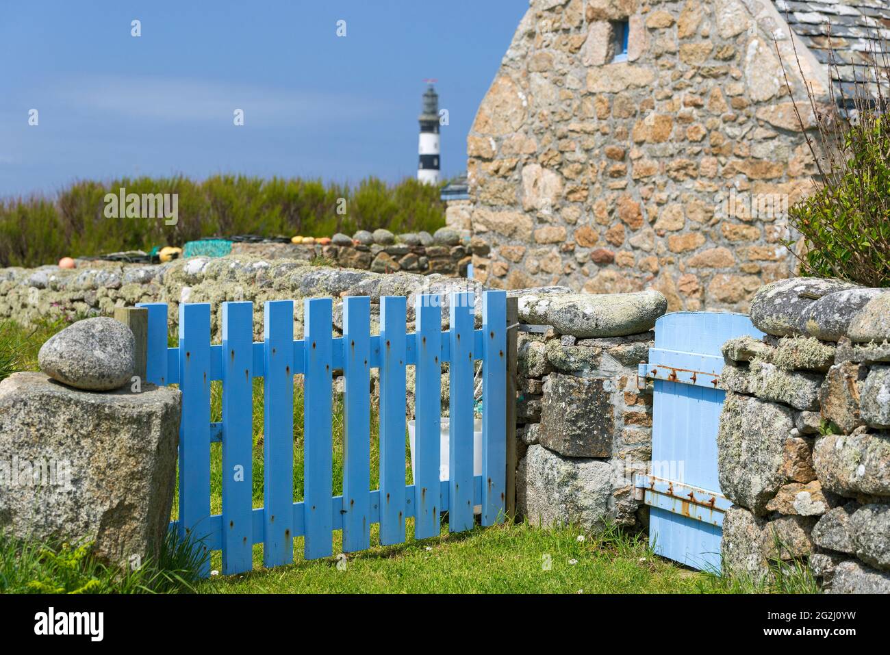 House and garden on Ouessant, view to the lighthouse Créac'h, Île d´Ouessant, France, Brittany, Finistère department Stock Photo