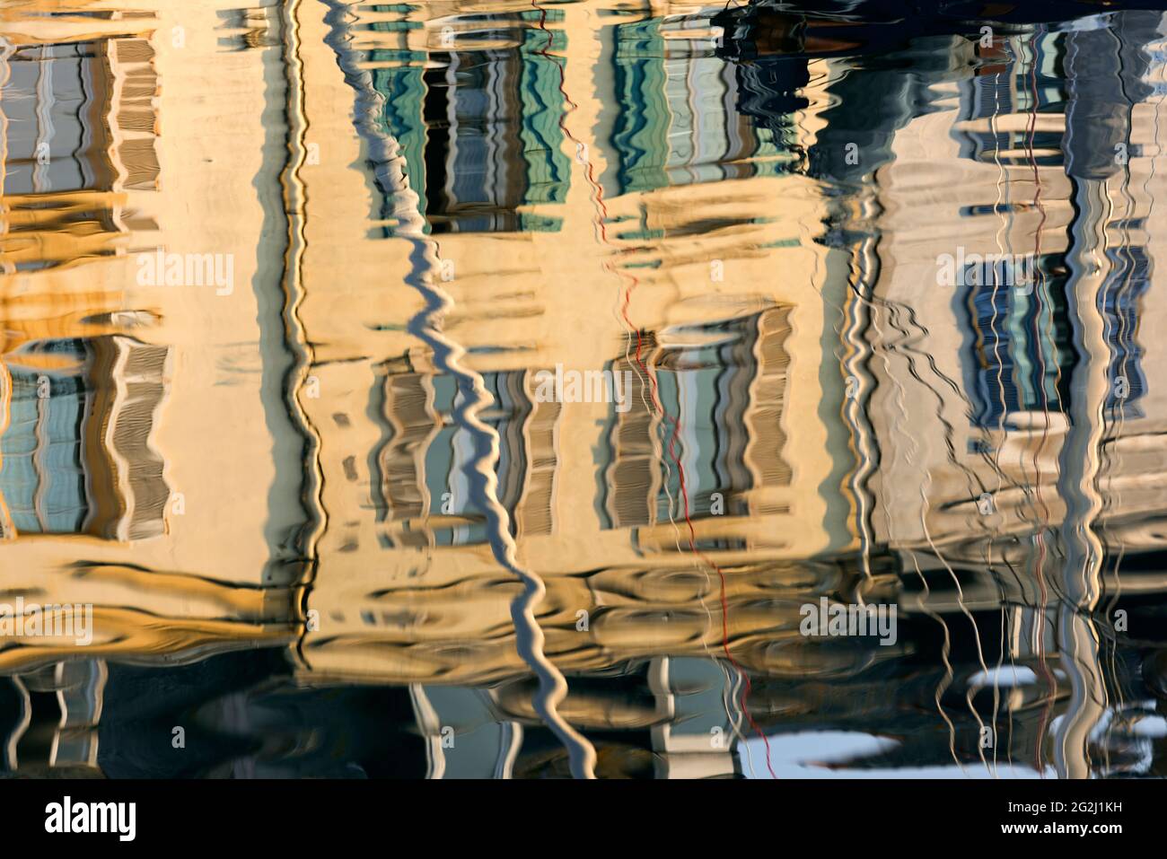 Facades of houses are reflected in the water in the harbor of Le Palais, evening light, France, Brittany, Belle-Ile-en-Mer, Morbihan department Stock Photo