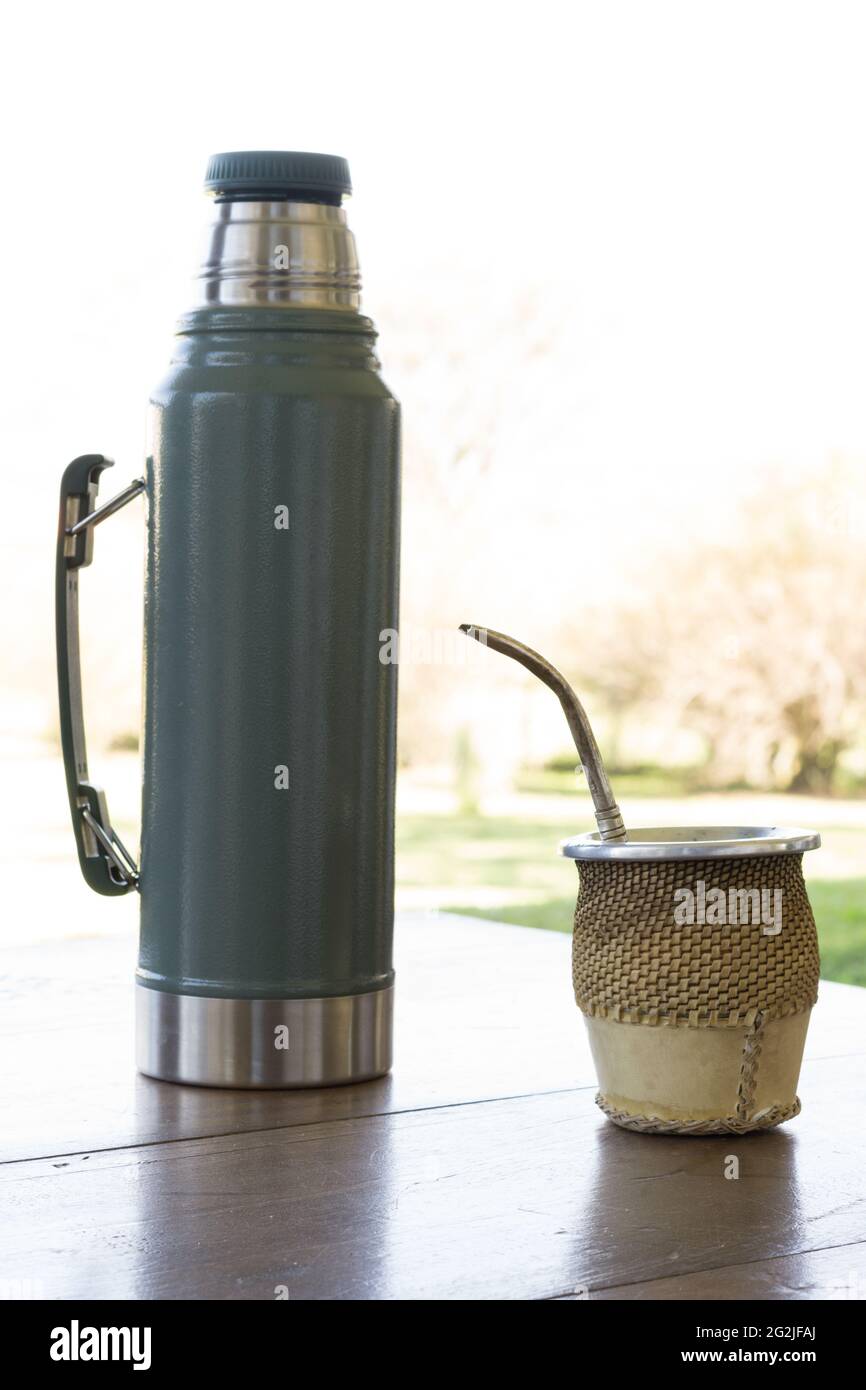 https://c8.alamy.com/comp/2G2JFAJ/mate-caffeine-rich-infused-drink-in-a-wood-cup-put-on-a-wooden-table-next-to-a-thermos-bottle-2G2JFAJ.jpg