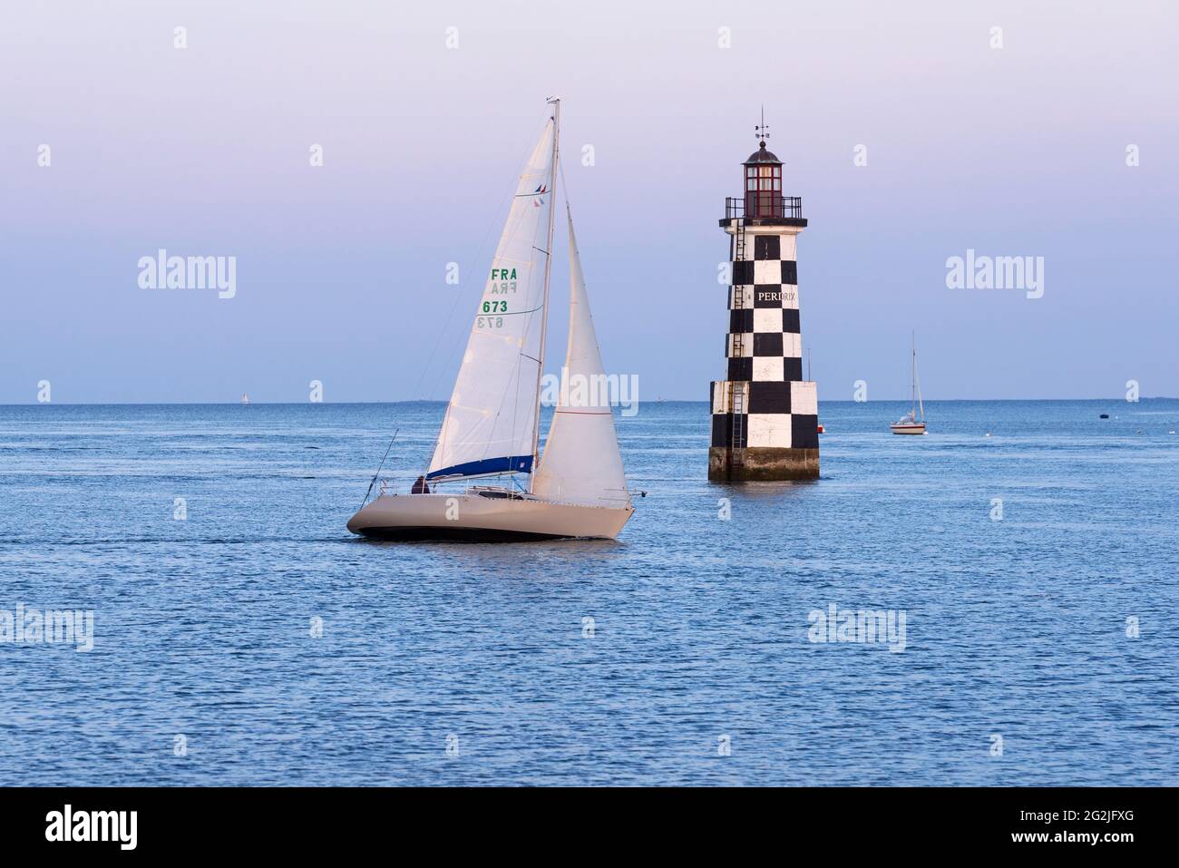 a sailing boat passes the lighthouse La Perdrix, Île-Tudy near Pont l´Abbé in South Finistère, evening mood, France, Brittany, Finistère department Stock Photo