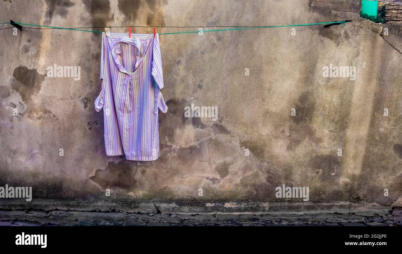 Laundry drying in front of an old house wall in Puisserguier in spring. Stock Photo