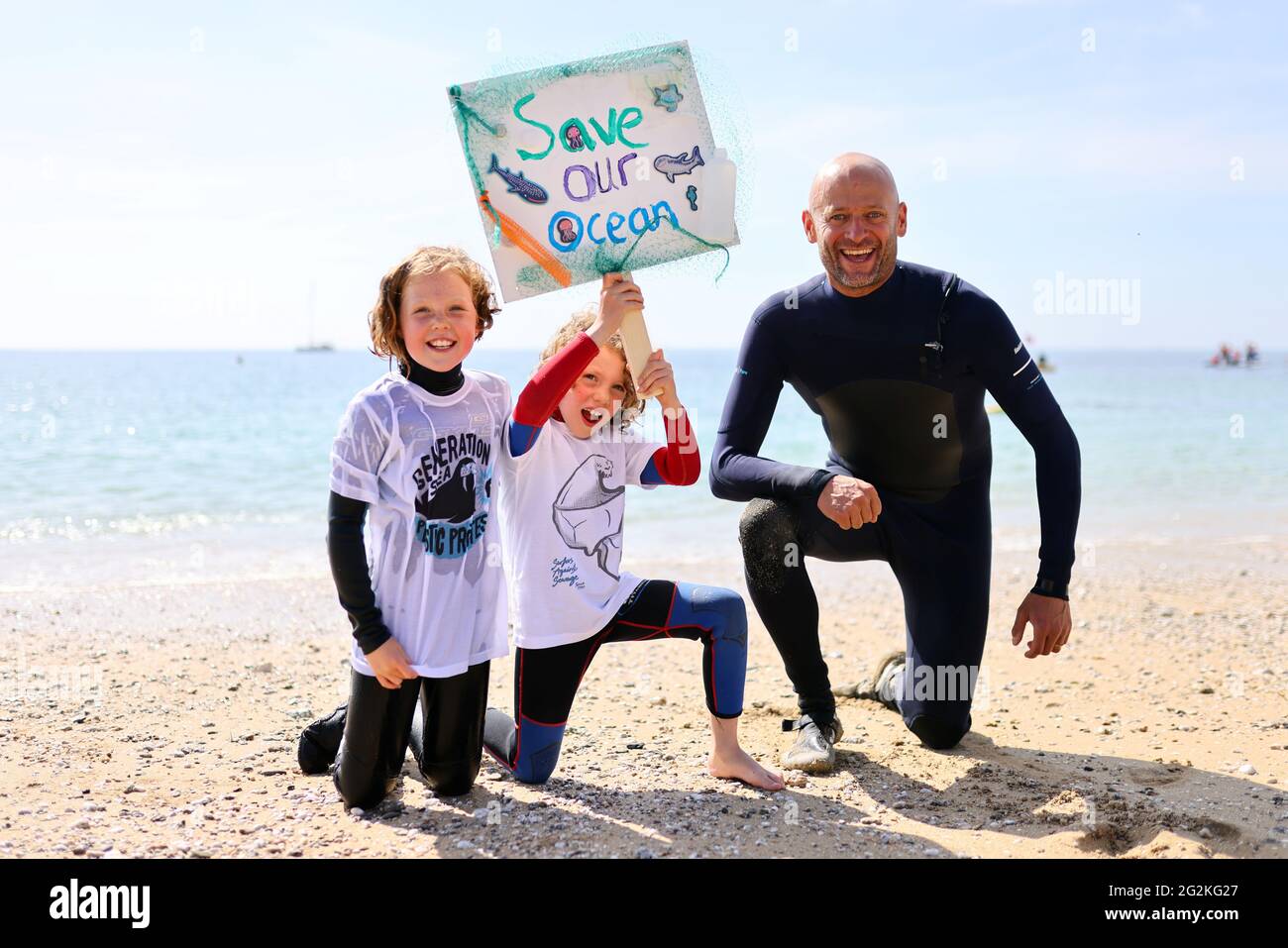 Hugo Tagholm, Chief Executive of the marine conservation and campaigning charity Surfers Against Sewage, poses for a photo with India Fleming and Sonny Fleming, in Gyllyngvase beach, Falmouth, during the G7 summit in Cornwall, Britain, June 12, 2021. REUTERS/Tom Nicholson Stock Photo