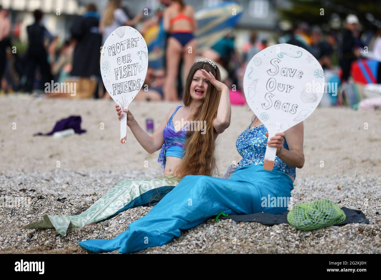Demonstrators hold signs in a protest in Gyllyngvase beach, Falmouth, during the G7 summit in Cornwall, Britain, June 12, 2021. REUTERS/Tom Nicholson Stock Photo