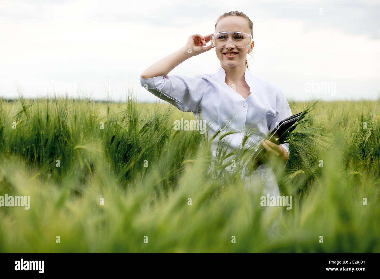 Young woman farmer wearing white bathrobe is checking harvest progress