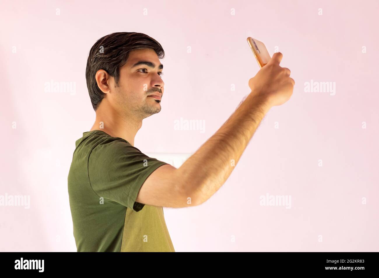 Young handsome Indian man taking selfie with mobile phone. Stock Photo