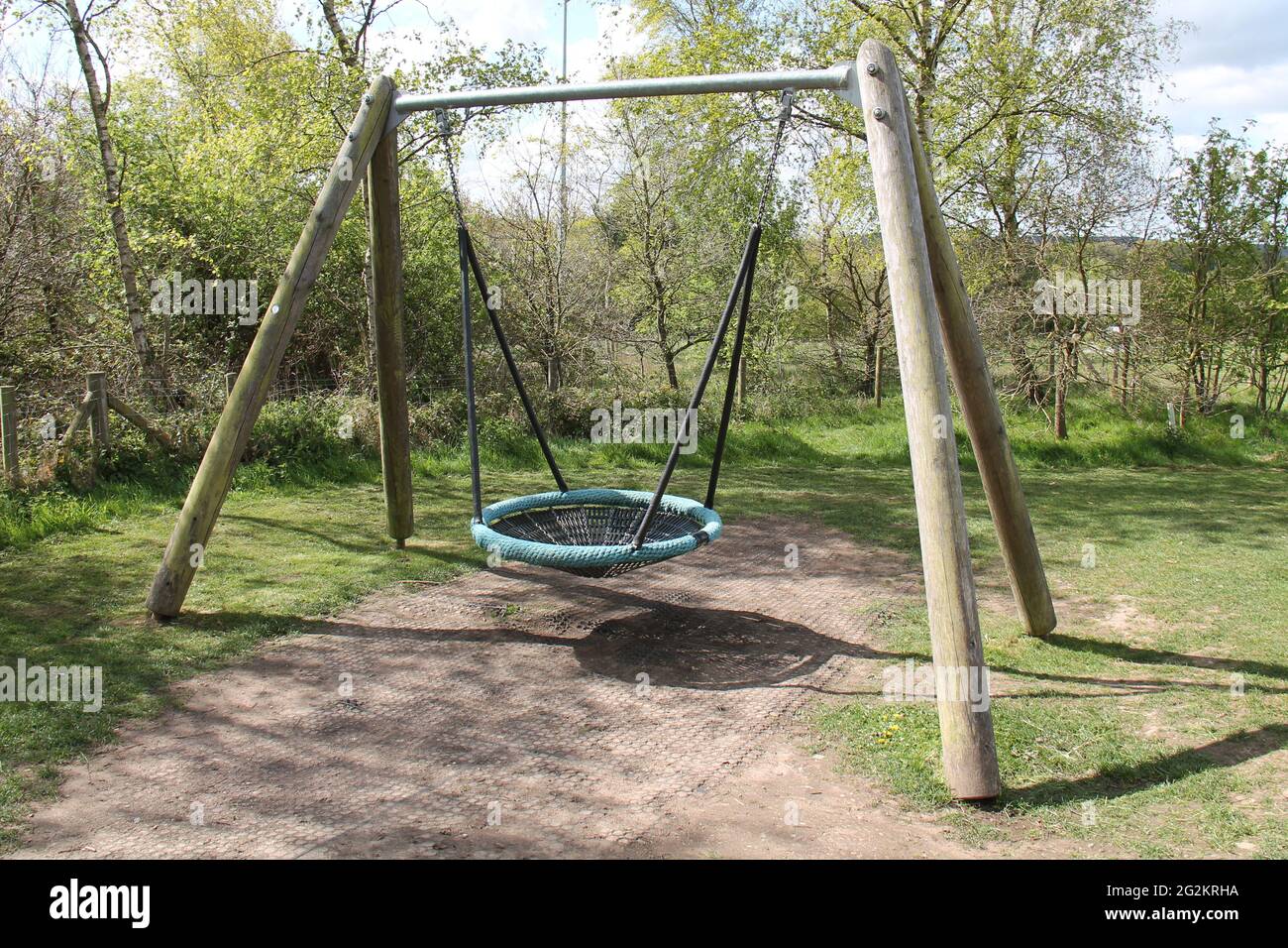 A Round Playground Net Swing on a Large Wooden Frame Stock Photo