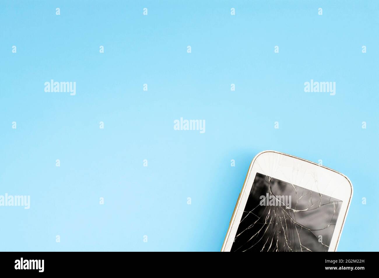 A broken touchscreen cell phone on blue background with free copy-paste ...
