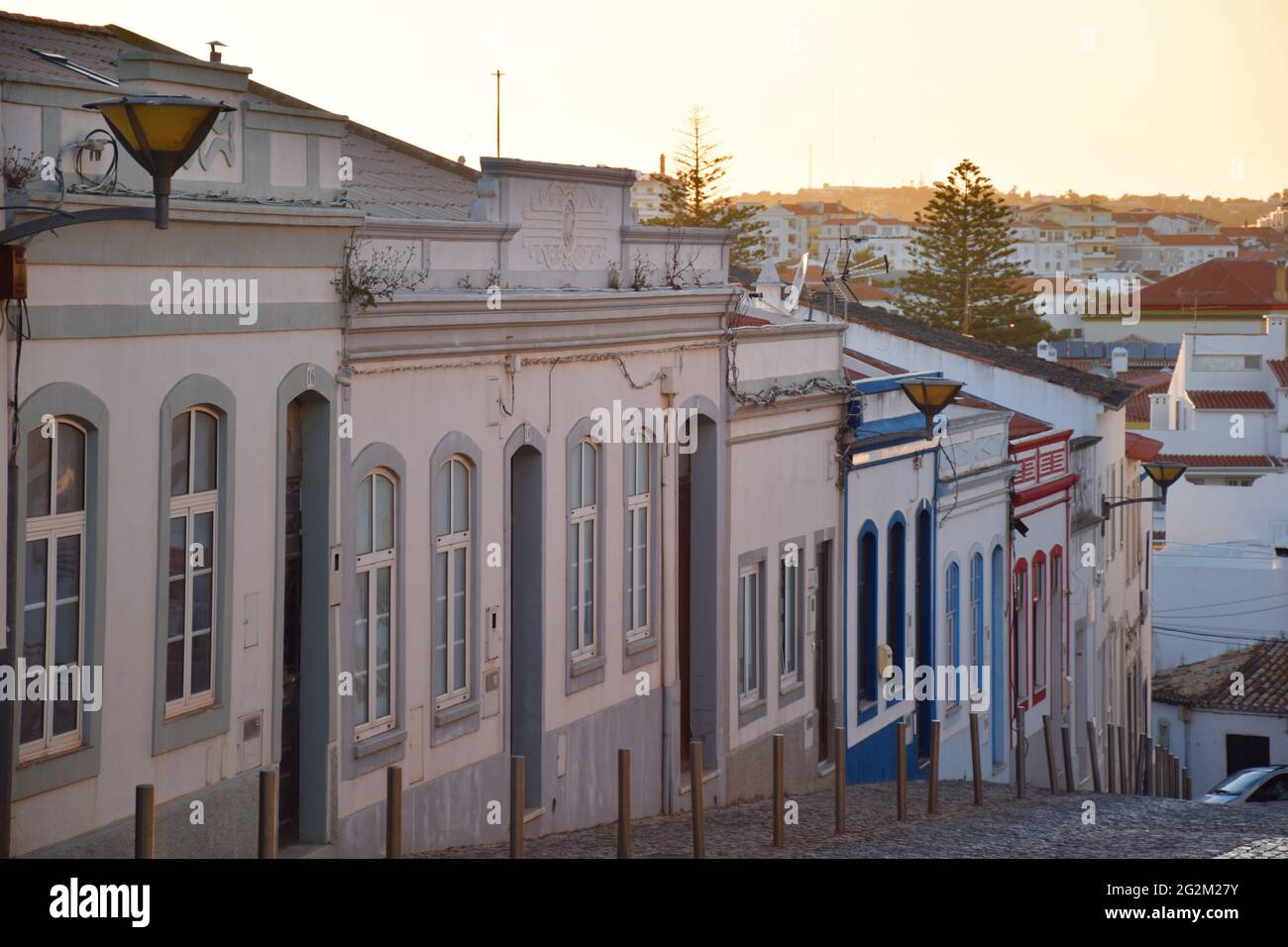 Old facades of houses on a descending street at sunset in the city of Lagos , Algarve, Portugal Stock Photo