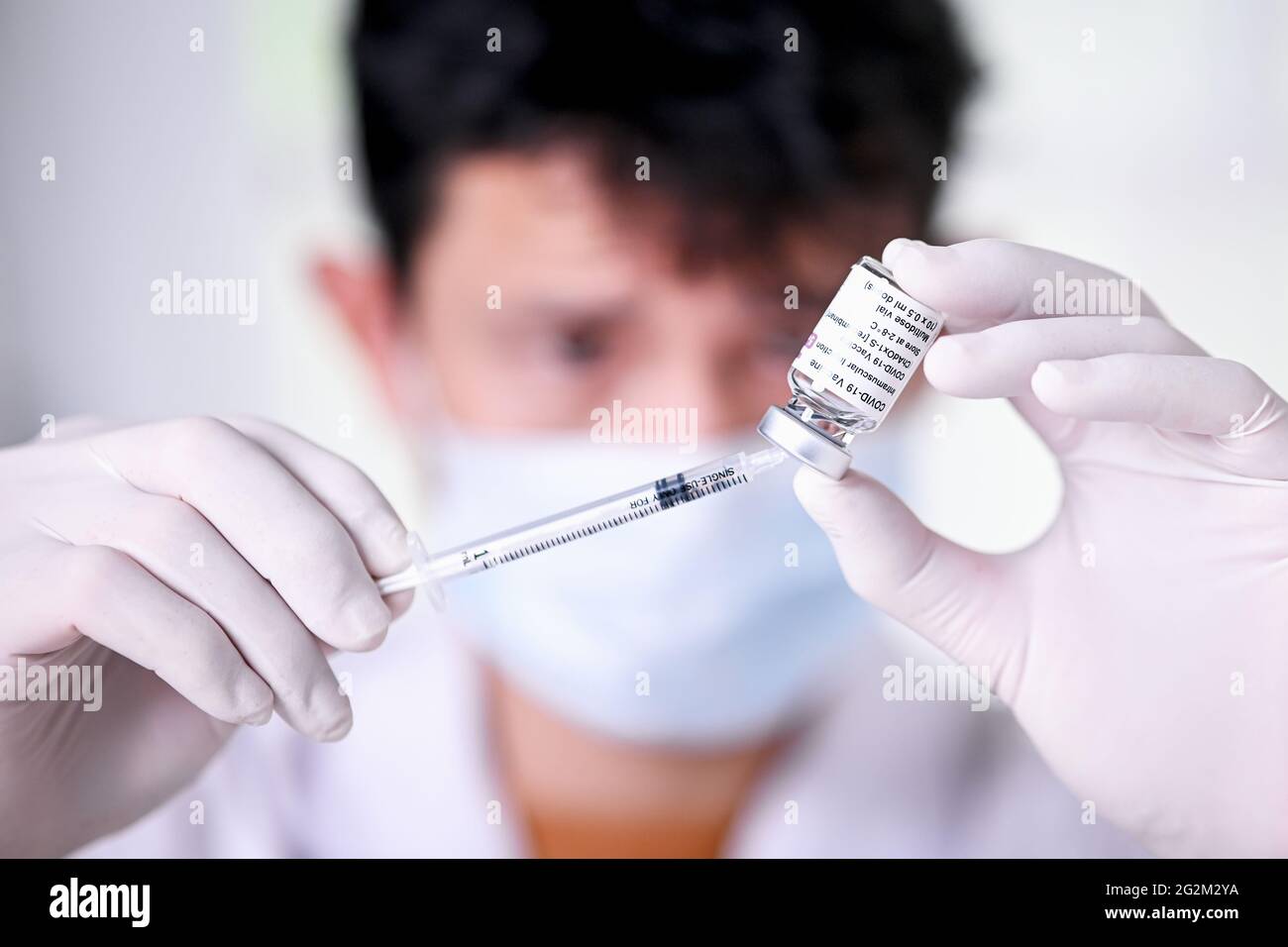 Doctor's hands in surgical gloves preparing COVID-19 vaccine for patient, ,COVID-19 vaccines can help reduce the transmissionor stop pandemic of the Stock Photo