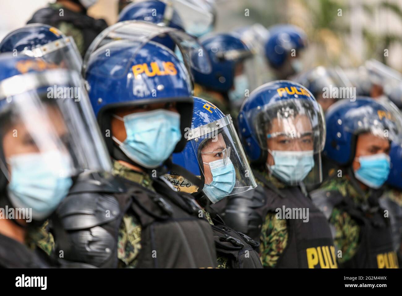 Metro Manila, Philippines. 12th June 2021. Anti-riot policemen take their positions as activists hold a protest to mark Independence Day outside the Chinese Consulate in the financial district of Makati. Various groups called on China to stop its maritime activities in the disputed South China Sea, which endangers peace and stability in the region. Credit: Majority World CIC/Alamy Live News Stock Photo