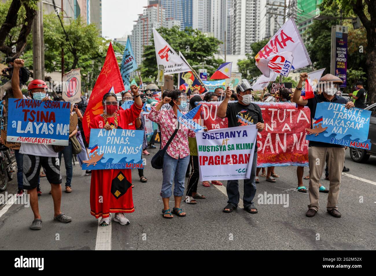 Metro Manila, Philippines. 12th June 2021. Activists shout slogans during a protest in front of the Chinese consulate marking Independence Day in the financial district of Makati. Various groups called on China to stop its maritime activities in the disputed South China Sea, which endangers peace and stability in the region. Credit: Majority World CIC/Alamy Live News Stock Photo