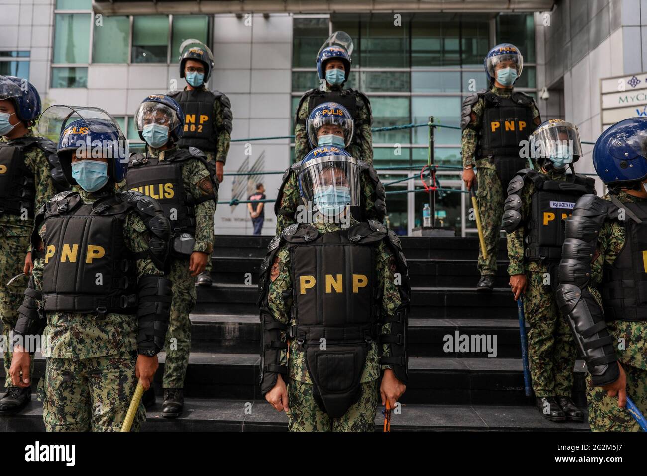 Metro Manila, Philippines. 12th June 2021. Anti-riot policemen take their positions as activists hold a protest to mark Independence Day outside the Chinese Consulate in the financial district of Makati. Various groups called on China to stop its maritime activities in the disputed South China Sea, which endangers peace and stability in the region. Credit: Majority World CIC/Alamy Live News Stock Photo