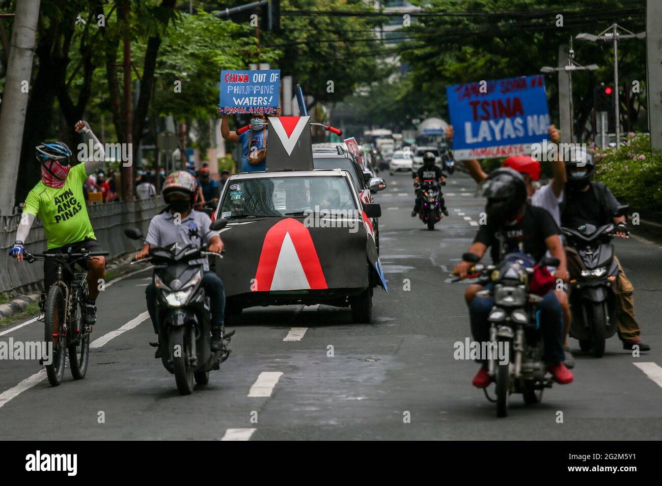 Metro Manila, Philippines. 12th June 2021. Activists carry signs as they hold a motorcade in front of the Chinese Consulate in the financial district of Makati. Various groups called on China to stop its maritime activities in the disputed South China Sea, which endangers peace and stability in the region. Credit: Majority World CIC/Alamy Live News Stock Photo