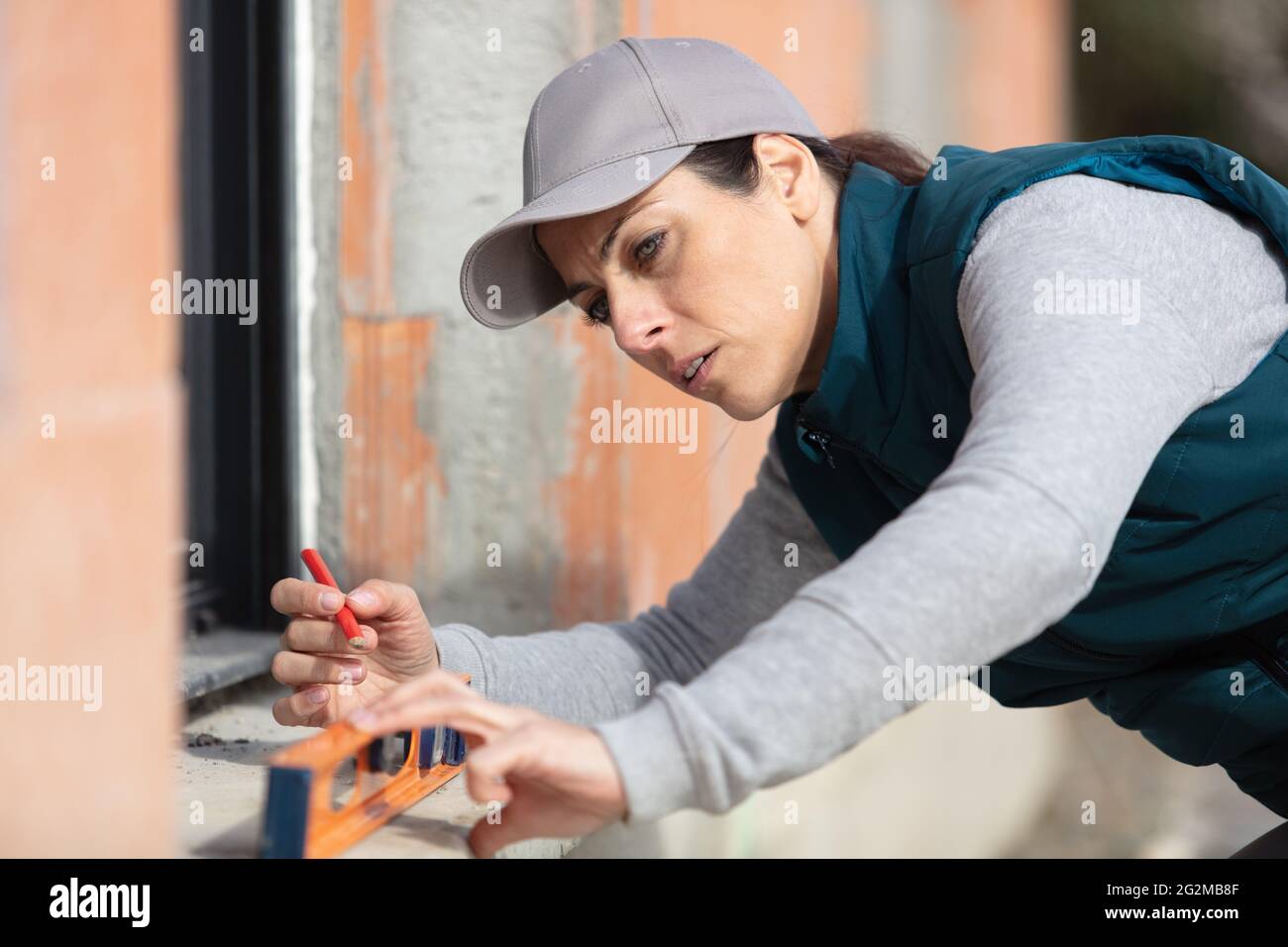 woman builder unscrews fastening screws handle window Stock Photo
