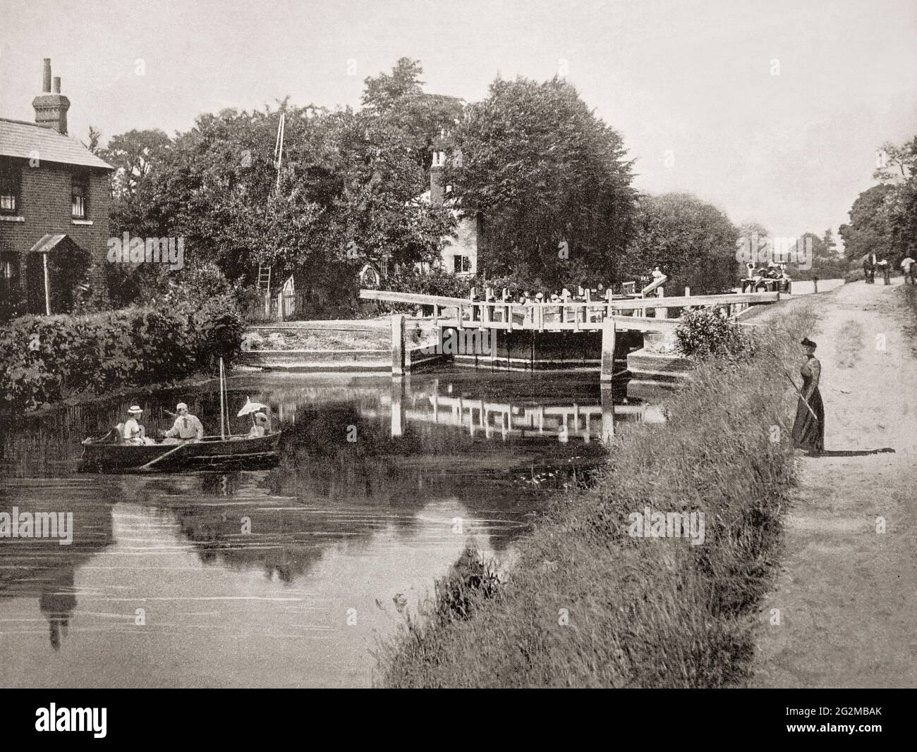A late 19th century view of people in a rowing boat below Sonning Lock, a lock and associated weir situated on the River Thames at the village of Sonning near Reading, Berkshire, England. The first lock was built by the Thames Navigation Commission in 1773 and it has been rebuilt three times since then, the last time being 1868. Stock Photo