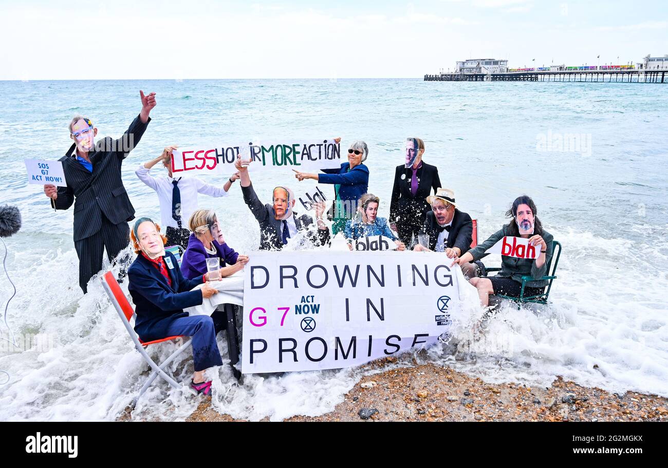 Worthing Sussex UK 12th June 2021 - Activists from Extinction Rebellion get wet in the sea as they take part in a protest on Worthing beach today as part of a weekend of action to coincide with the G7 summit and highlight the effects of climate change and rising sea levels  : Credit Simon Dack / Alamy Live News Stock Photo