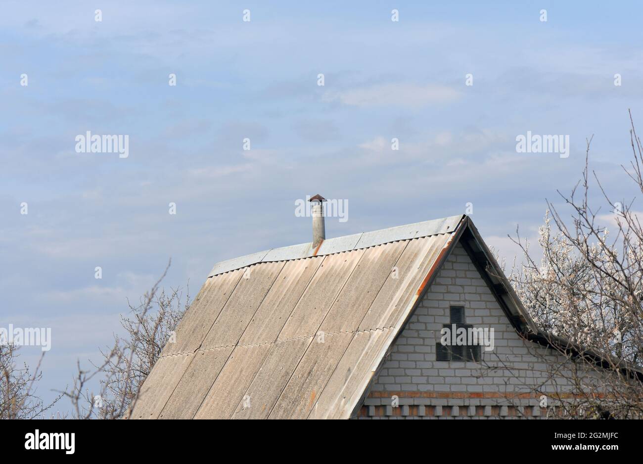 House with a weathered and aged roof under the cloudy blue sky Stock ...