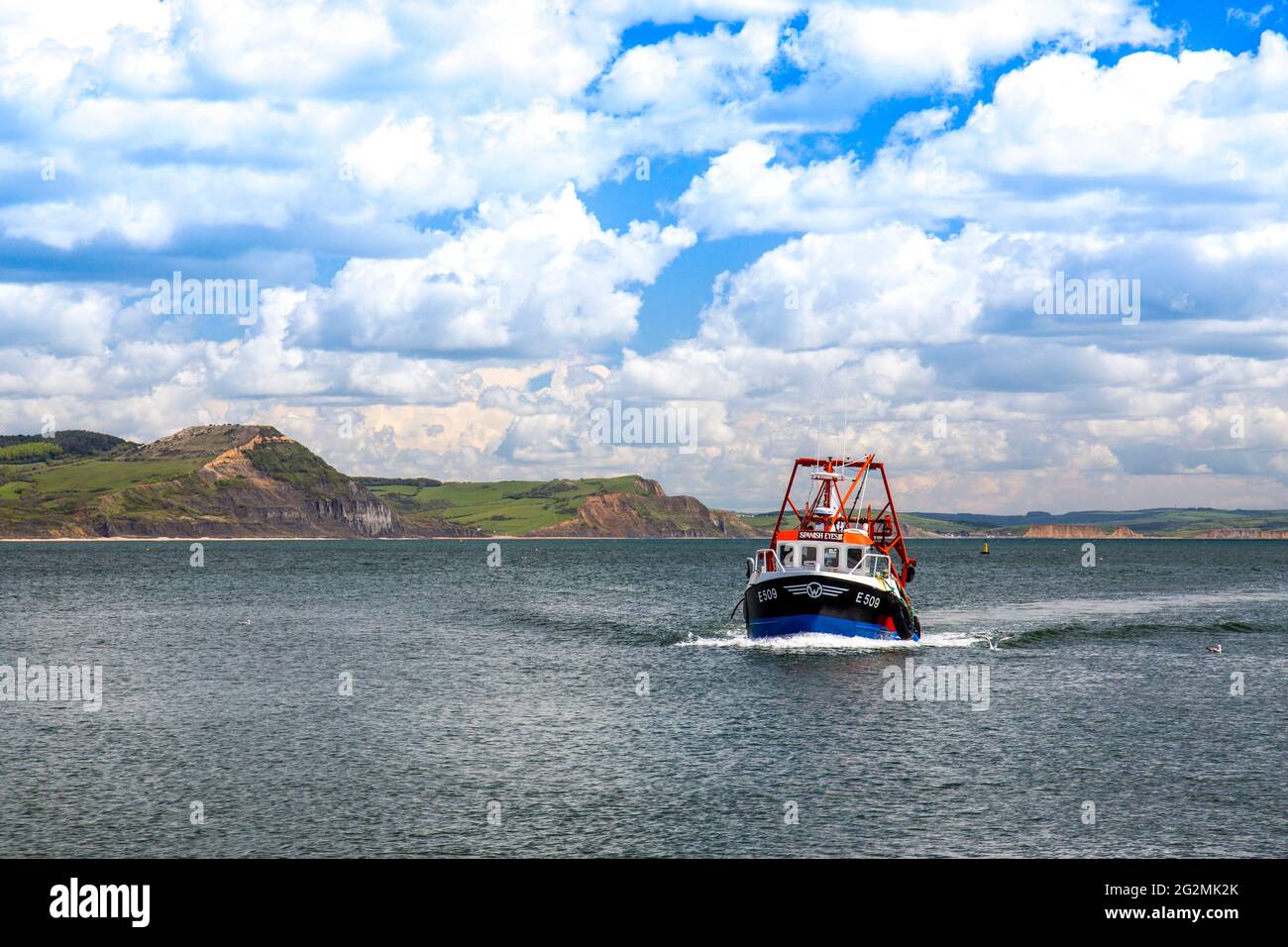 A fishing boat returning to the harbour at Lyme Regis on the Jurassic ...
