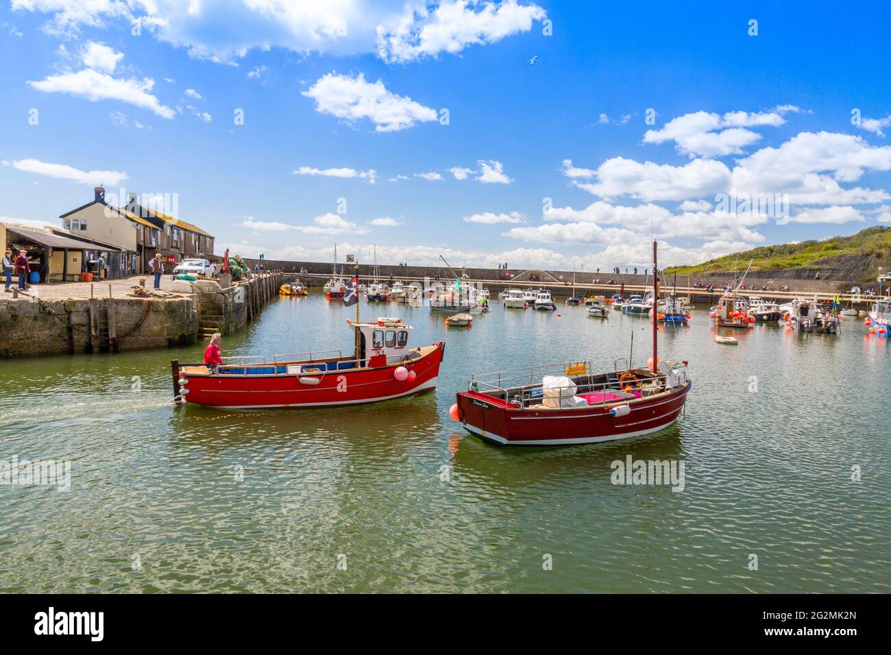 A fishing boat returning to the harbour at Lyme Regis on the Jurassic ...