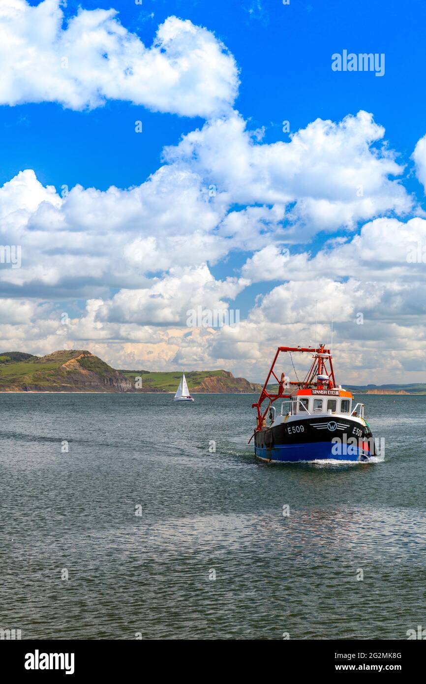 A fishing boat returning to the harbour at Lyme Regis on the Jurassic ...