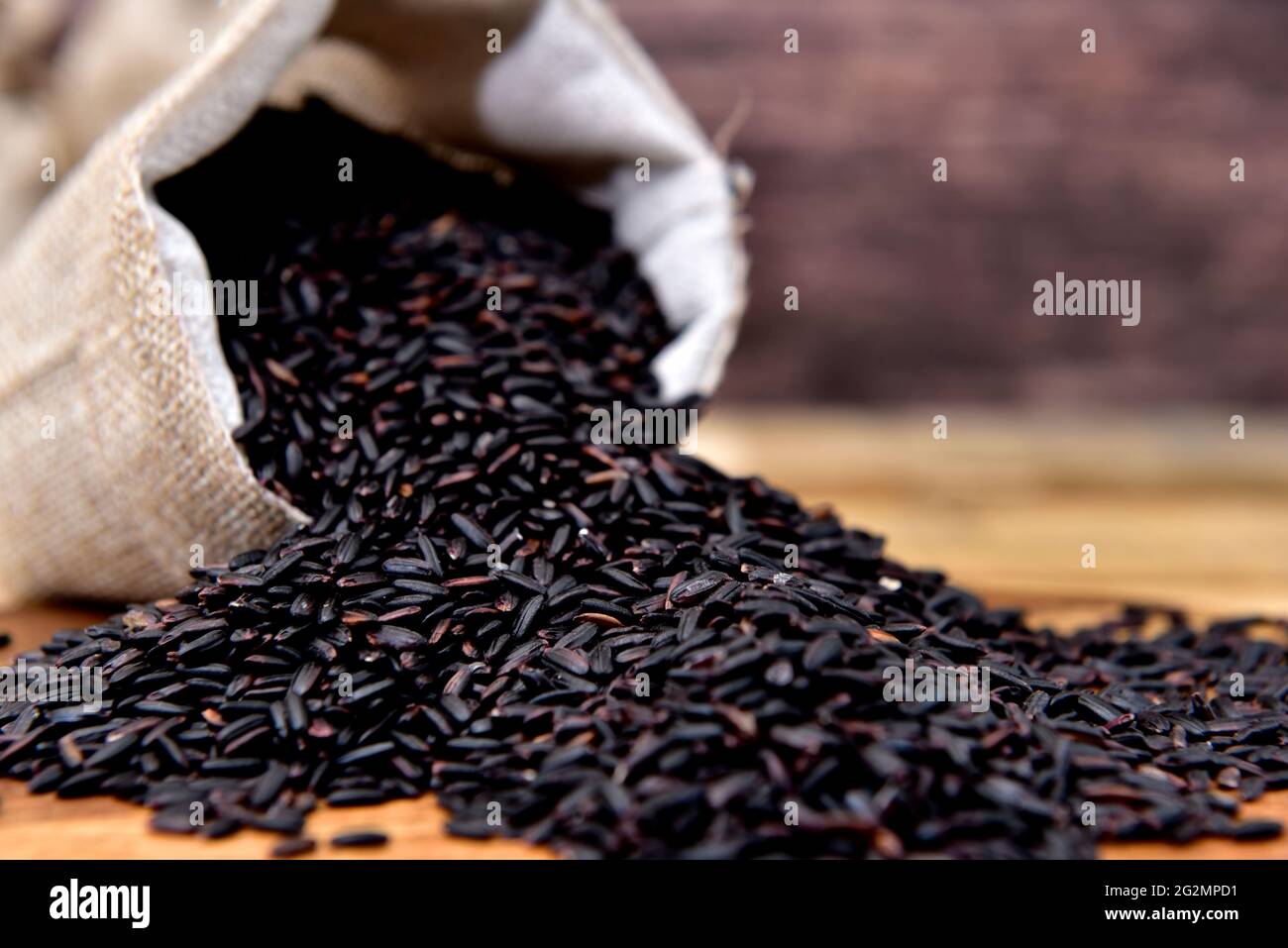 Organic black rice in a rustic sack Stock Photo