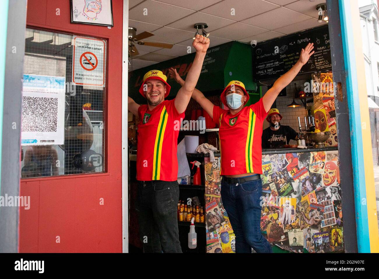 Cardiff, Wales, UK. 12th June, 2021. Wales football supporters in celebratory mood in a Cardiff city centre cafe ahead of their side's opening match of the coronavirus delayed Euro 2020 tournament against Switzerland in Azerbaijan. Credit: Mark Hawkins/Alamy Live News Stock Photo
