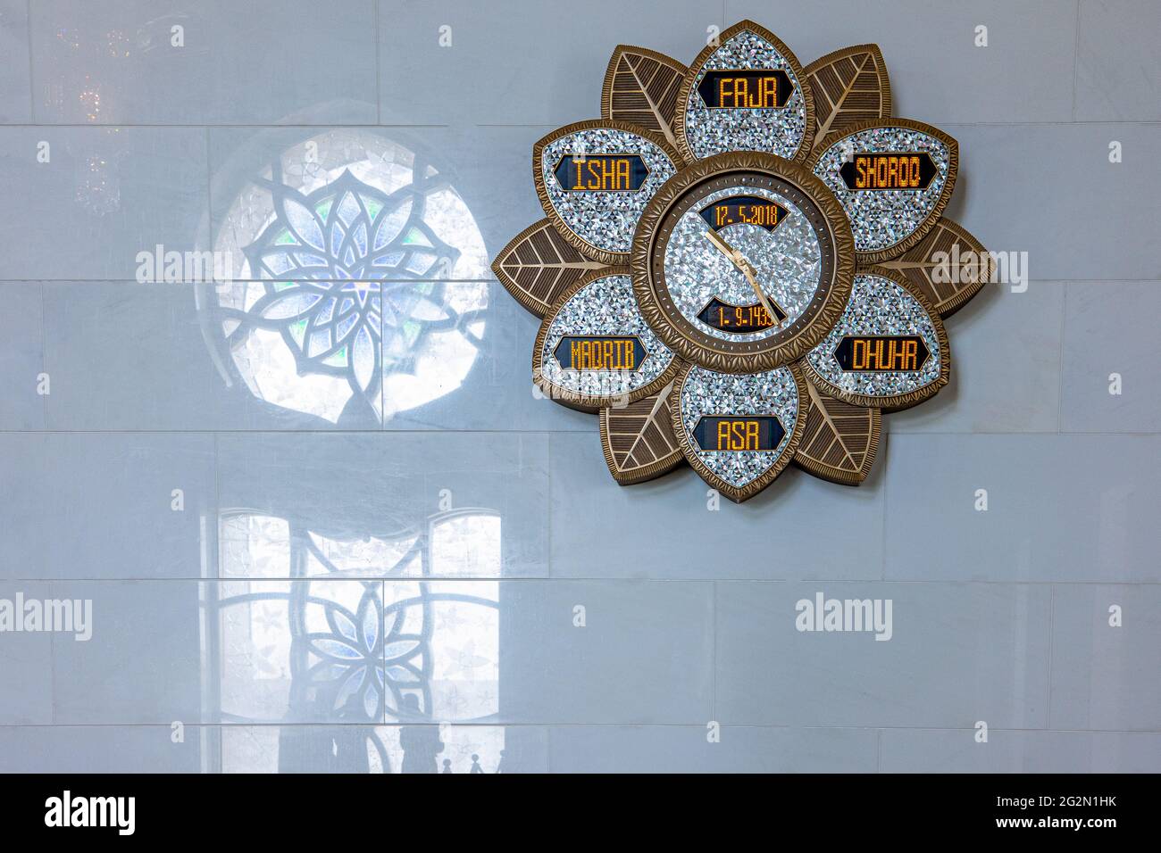 Abu Dhabi, United Arab Emirates - May 17, 2018: A wall with reflections and decorated clock in the entrance of the  Sheick Zayed Grand Mosque Stock Photo