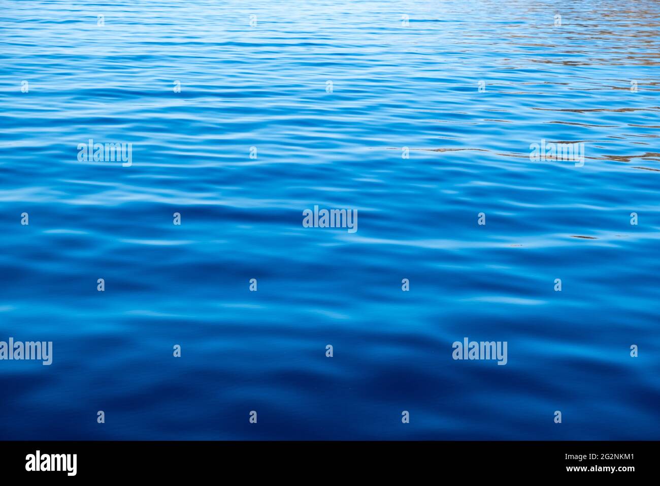 Sea water surface calm with small ripples, deep blue color background ...