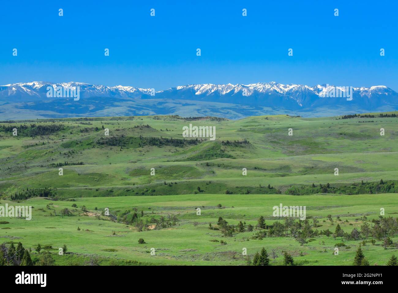 distant beartooth and absaroka mountains above rolling foothills near big timber, montana Stock Photo