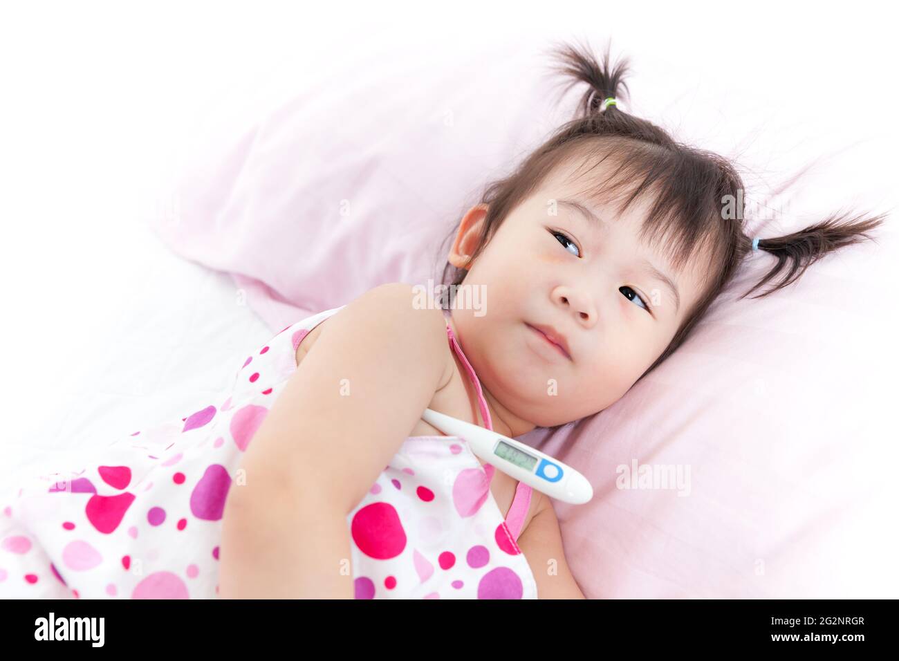Little asian (thai) girl lying on sickbed with digital thermometer in