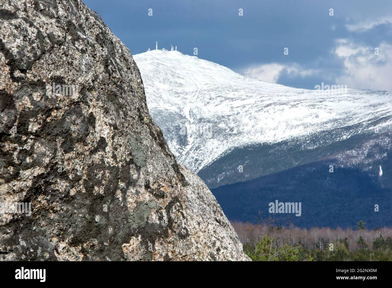 Hugh boulder (erratic) framing snowcapped summit of New Hampshire's
