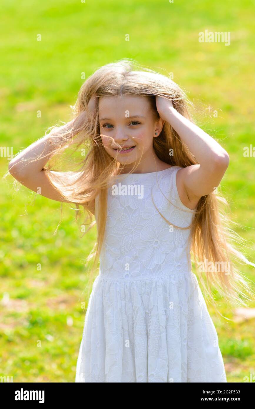 Beautiful blue-eyed girl with long blond hair in a white dress walking in  the flower garden. Summer and spring bright, emotional photo Stock Photo -  Alamy