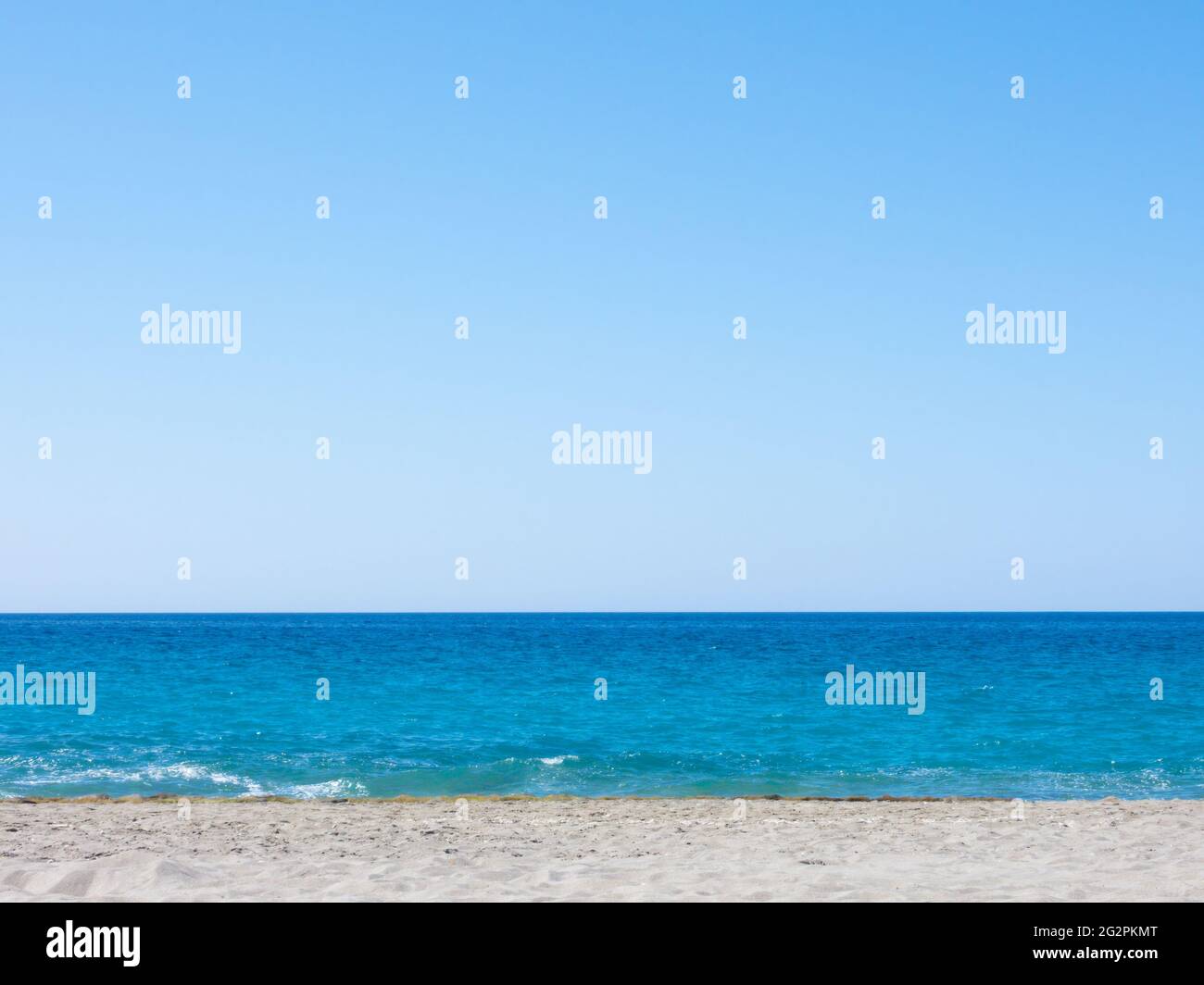 Beach background with calm sea, clear sky and grey sand Stock Photo - Alamy