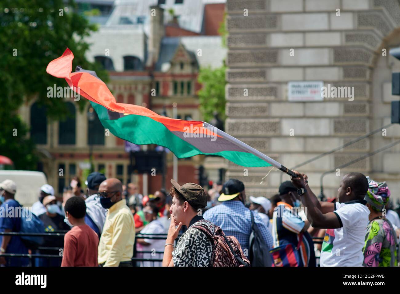 London  UK - 12 June 2021 - Protester waving Biafran large flag at Biafra protest on corner of whitehall and westminster square in Central london whi Stock Photo