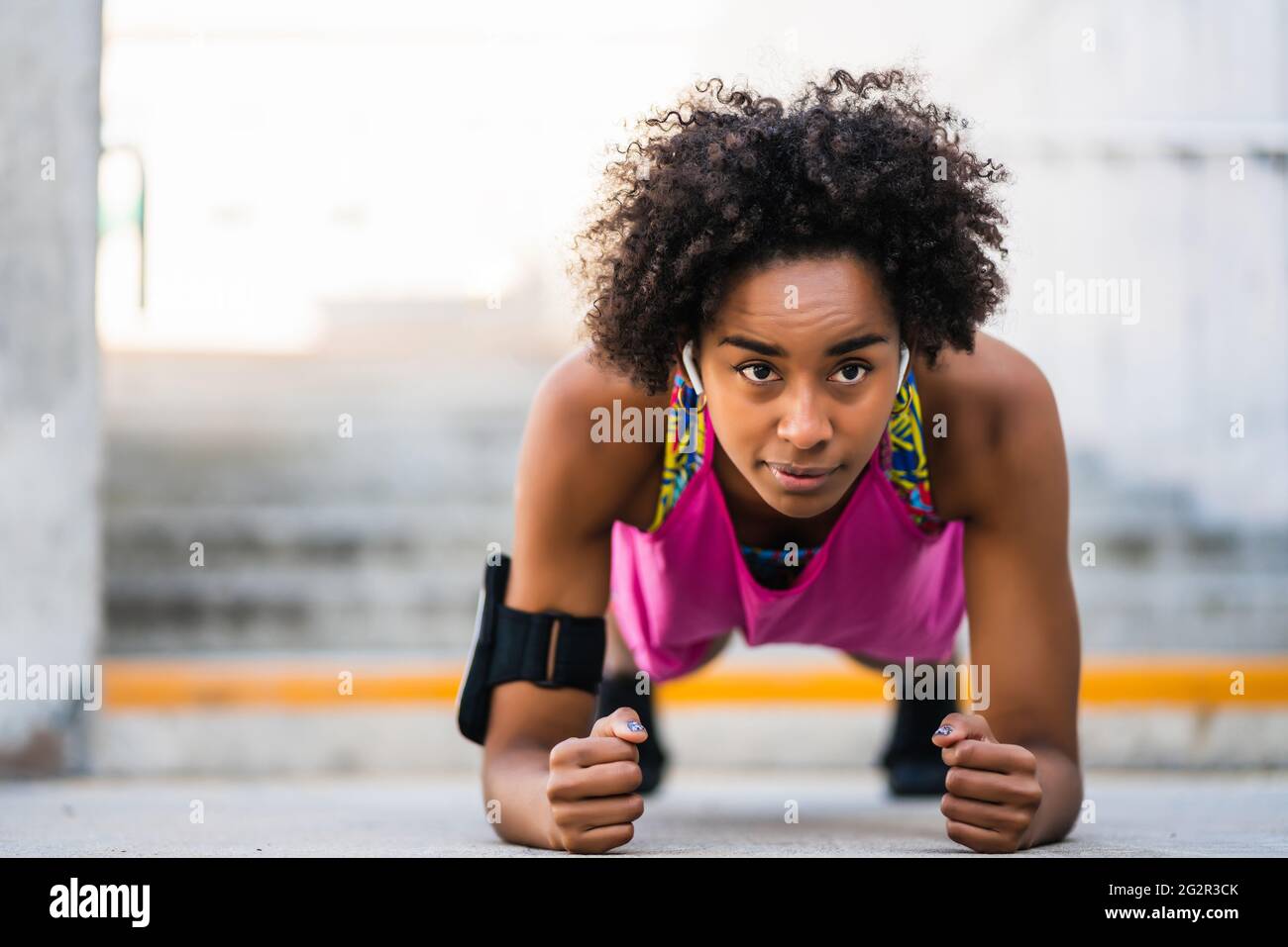 Afro athlete woman doing pushups outdoors. Stock Photo