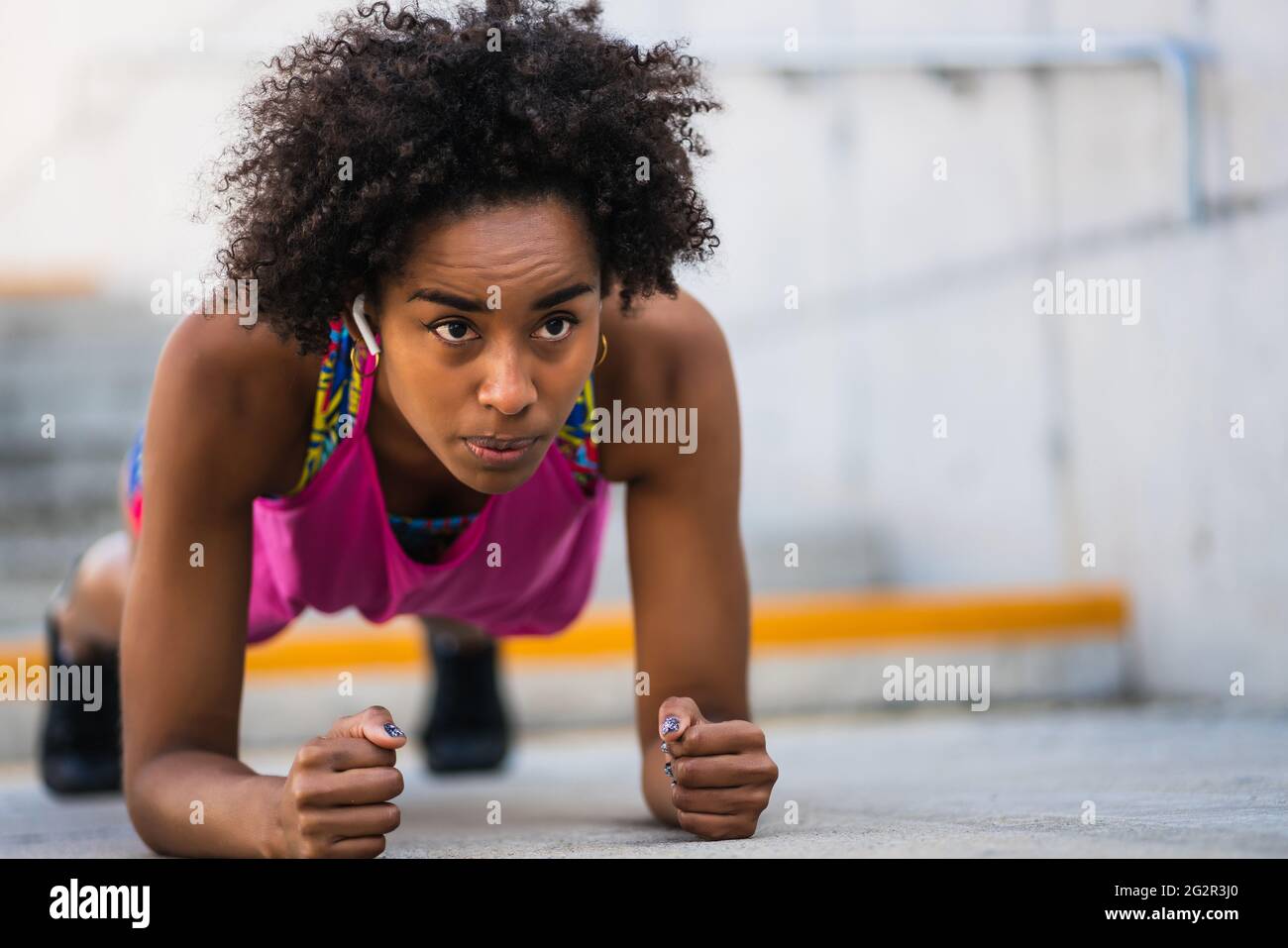 Afro athlete woman doing pushups outdoors. Stock Photo