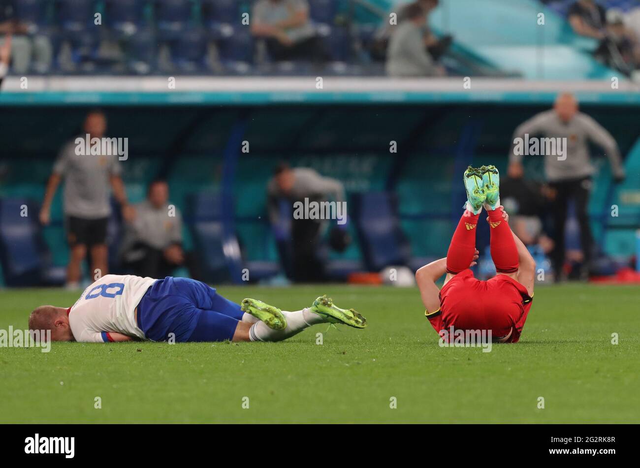 12 June 2021, Russia, St. Petersburg: Football: European Championship, Belgium - Russia, preliminary round, Group B, Matchday 1 at St. Petersburg Stadium. Dmitri Barinov (Russia) and Dries Mertens (Belgium, r) lie on the turf after a collision. Important: For editorial news reporting purposes only. Not used for commercial or marketing purposes without prior written approval of UEFA. Images must appear as still images and must not emulate match action video footage. Photographs published in online publications (whether via the Internet or otherwise) shall have an interval of at least 20 seconds Stock Photo