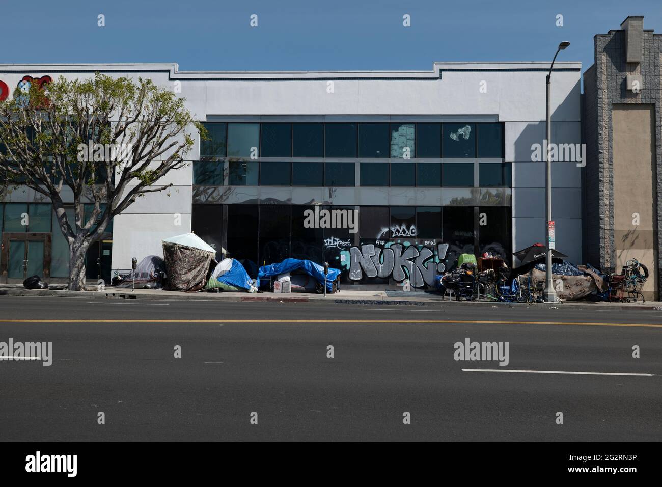 Los Angeles, CA USA - March 16, 2021: Homeless encampent in front of a graffiti covered store in Los Angeles Stock Photo