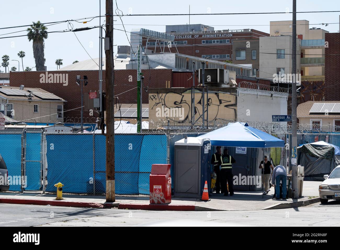 Los Angeles, CA USA - May 27 , 2021: Portable restrooms and security outside a fenced in homeless encampment run by the city in East Hollywood Stock Photo