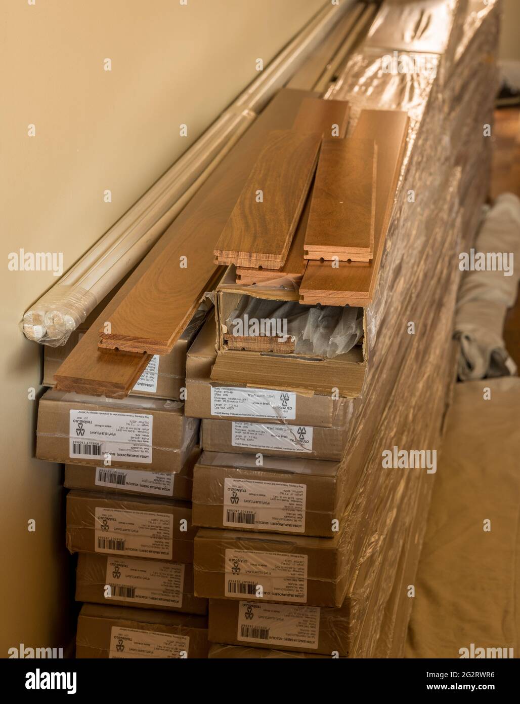 Morgantown, WV - 6 June 2021: Stack of boxes of Brazilian Cherry exotic hardwood flooring planks ready for installation Stock Photo