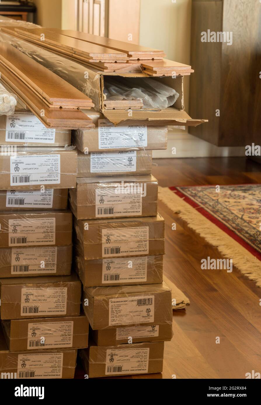 Morgantown, WV - 6 June 2021: Stack of boxes of Brazilian Cherry exotic hardwood flooring planks ready for installation Stock Photo