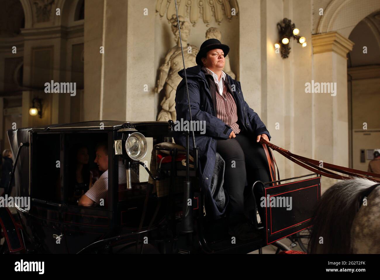 Like film frame, Those who tour the old town by horse-drawn carriage, in the Hofburg palace passage corridor Stock Photo