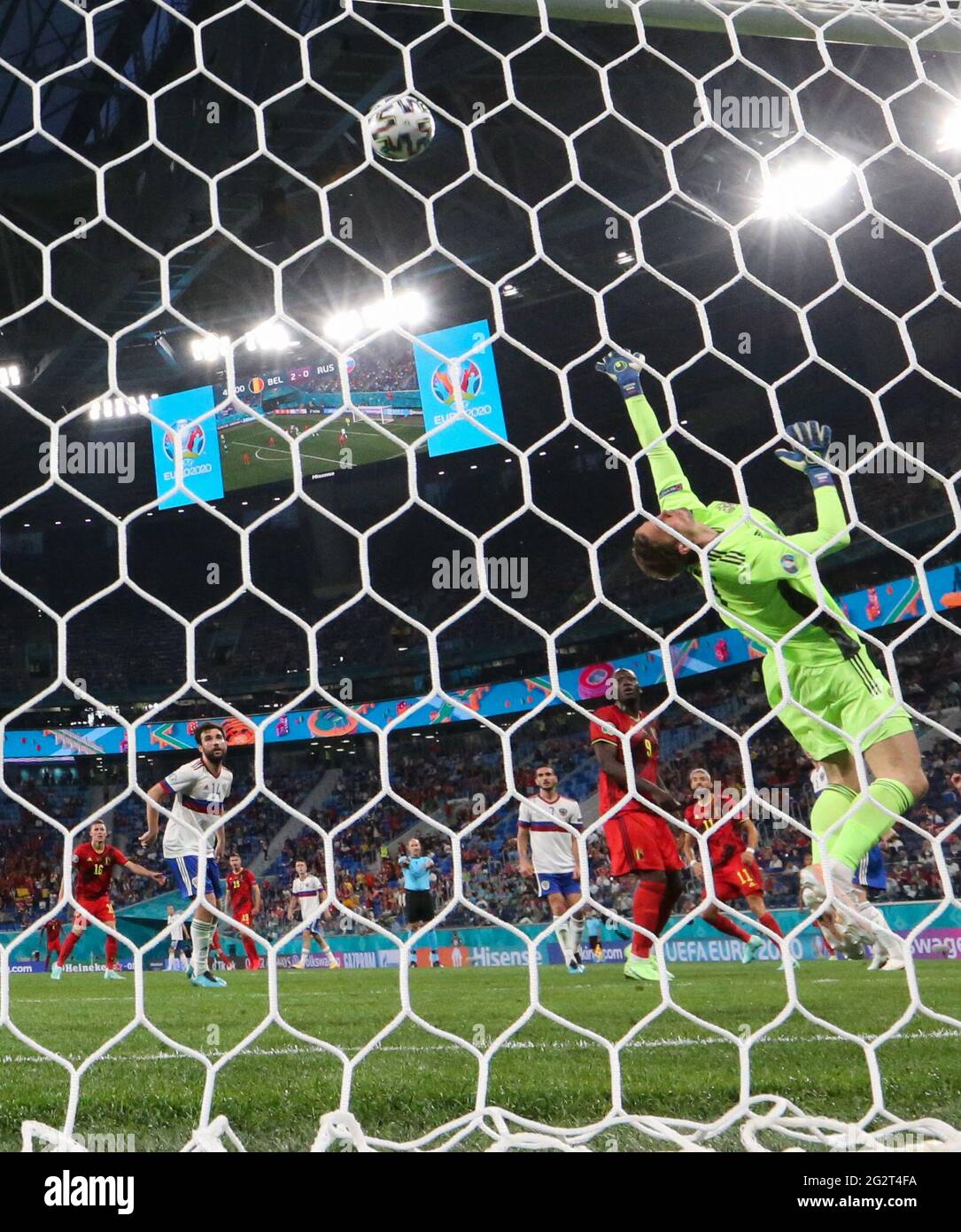 12 June 2021, Russia, St. Petersburg: Football: European Championship, Belgium - Russia, preliminary round, Group B, 1st matchday at St. Petersburg Stadium. Goalkeeper Anton Schunin (Russia) can't stop Romelu Lukaku (Belgium, 3.f.r) from scoring the 3:0 goal. Important: For editorial news reporting purposes only. Not used for commercial or marketing purposes without prior written approval of UEFA. Images must appear as still images and must not emulate match action video footage. Photographs published in online publications (whether via the Internet or otherwise) shall have an interval of at l Stock Photo