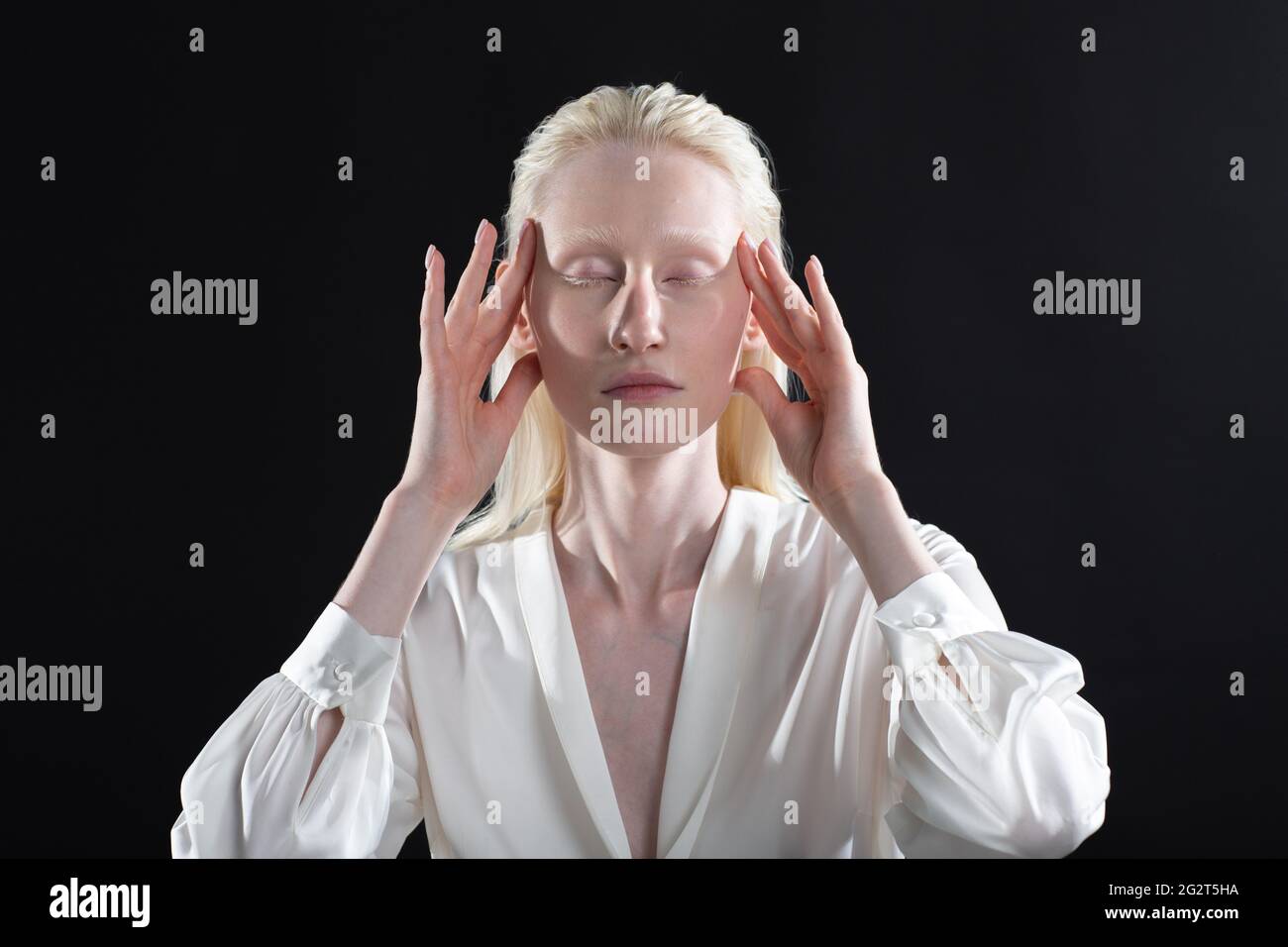 Young blonde albino woman doing face building facial gymnastics self massage and rejuvenating exercises on black background Stock Photo Alamy