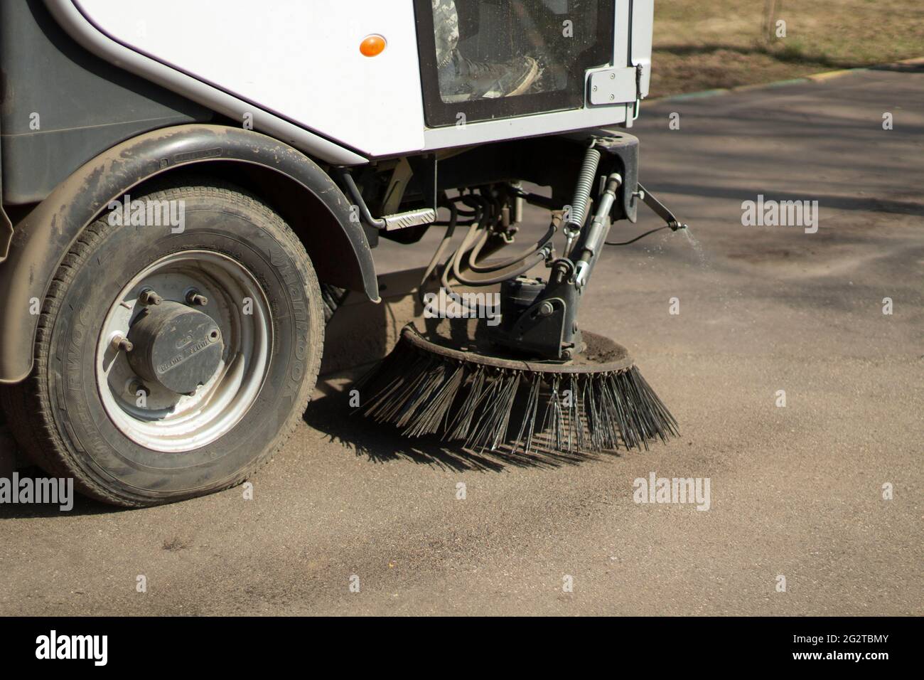 The sweeper is sweeping the asphalt. Cleaning the path with a cleaning